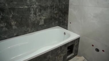Tadilat sırasında boş bir banyo. Yeni bir küvet kuruldu, duvarlara yeni seramik fayanslar yapıştırıldı..