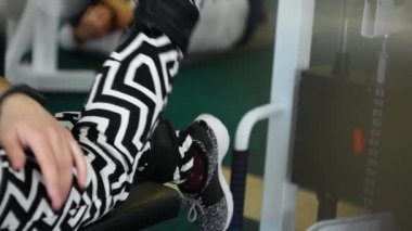 İyileşme, ilaç, spor, sağlık hizmetleri dışında. Yaşlı bir kadın spor kulübünde, spor salonunda bacaklarını rehabilitasyon simülatöründe çalıştırıyor. Fiziksel yaralanmalardan sonra rehabilitasyon, bacaklarda ağrı..