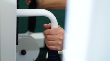 Spor kulübünde spor salonundaki egzersiz makinesinin sapına kadın eli yapıştır. Yaşlı kadın özel teçhizat üzerine tıbbi maliye kültürü ile ilgileniyor. Yaraların iyileşmesi, burkulmalar..