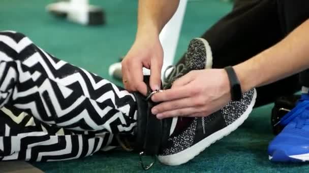 Tangan Close Dari Pelatih Perempuan Menempatkan Peralatan Pada Kaki Seorang — Stok Video