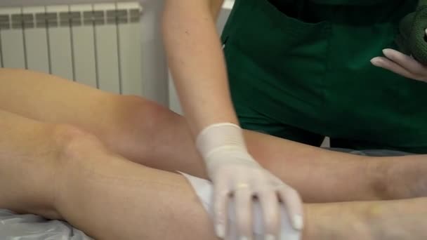 Ung Flicka Smetas Med Lotion Fötterna Med Servett Ett Ingrepp — Stockvideo