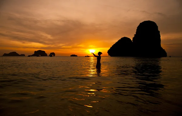 Atardecer silueta de mujer con sol en las manos, Tailandia —  Fotos de Stock