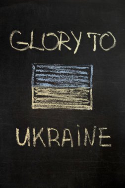 Kara tahtada tebeşirle Ukrayna 'nın şanlı yazıtları. Tebeşirle çizilmiş Ukrayna bayrağı. dikey
