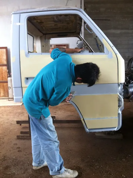 Mecánico preparando el cuerpo de un coche para un trabajo de reparación de pintura —  Fotos de Stock