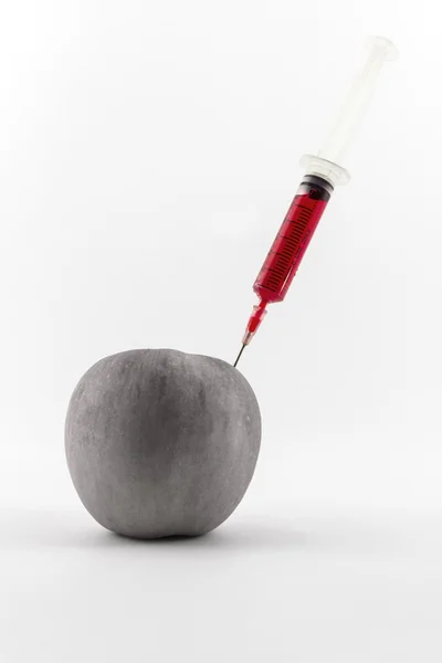 Roter Apfel mit einer Spritze. — Stockfoto