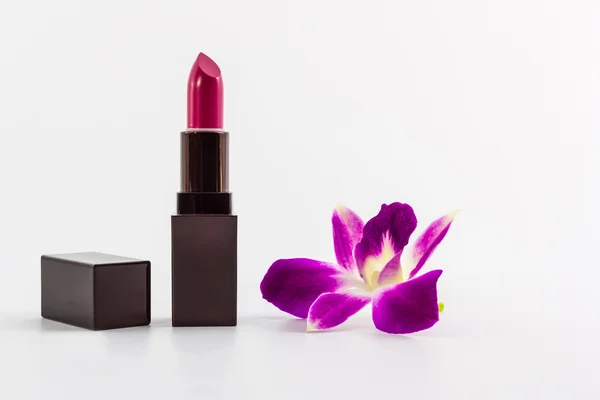 Lápiz labial púrpura con ruta de recorte y orquídea púrpura . — Foto de Stock