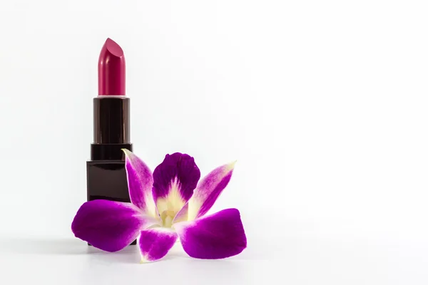 Lápiz labial púrpura con orquídea de flores . — Foto de Stock