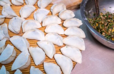 Sazlık tabakta çiğ Çin mantısı buğulamaya hazır.