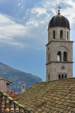 çan kulesi ve dağ zemin üzerine kırmızı-turuncu çatı ve