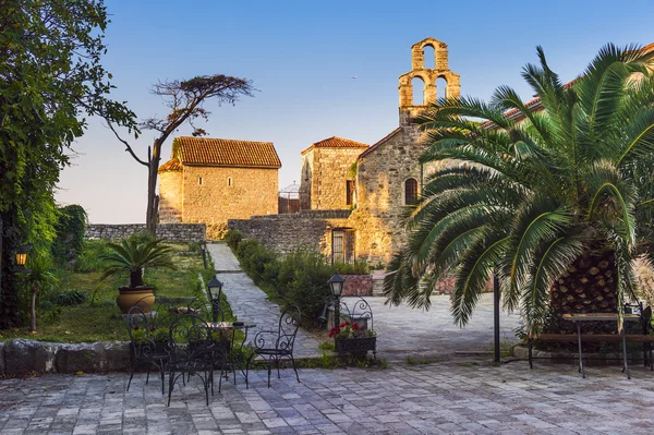 Vieille ville, place avec des bâtiments en pierre, une vieille église et un palmier Images De Stock Libres De Droits
