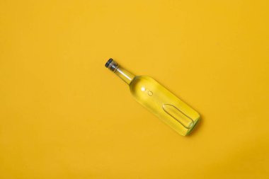 Sarı arka planda bir şişe tekila, mezcal veya votka.