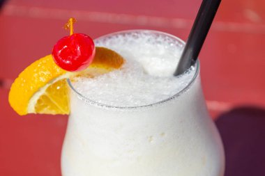 Alkollü pina colada, bir dilim portakal ve kirazlı.