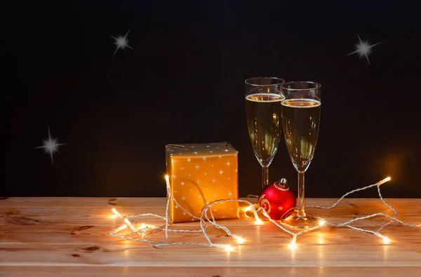 Sklenice Šampaňským Vánoční Dárek Míč Zářící Vánoční Světla Tmavém Pozadí — Stock fotografie