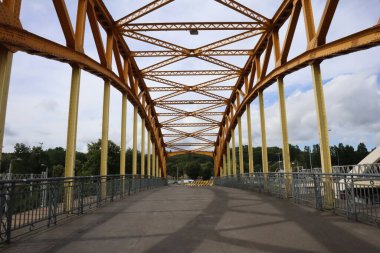 Metal rusty yellow bridge over the railroad