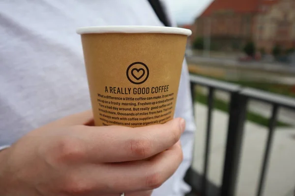 Man's hand holding a glass of coffee