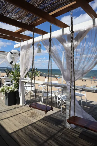 Sea view, swings, white wooden swings on the beach