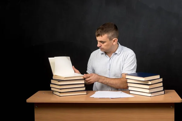 Man European Appearance Sits Desk Books Background Slate Wall Teacher — Foto de Stock