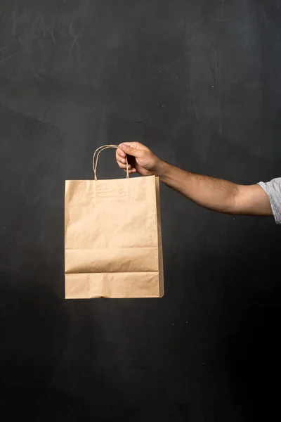 craft bag on a black background in hand. place for text. sales, shopping