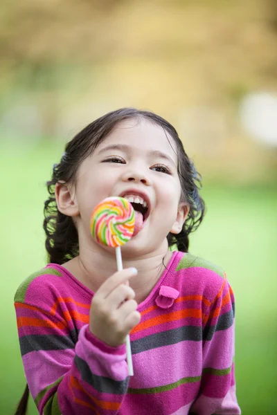 Littler flicka Njut Njut med godis — Stockfoto