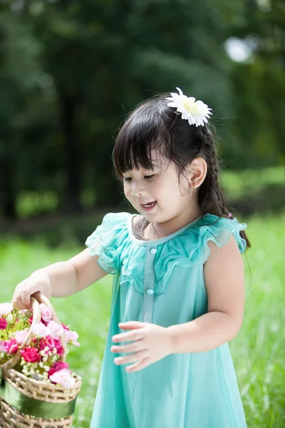 Little Asian girl with basket of flower — Stock Photo, Image