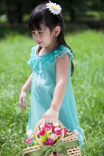 Little Asian girl with basket of flower — Stock Photo, Image