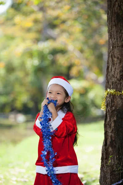 Kleines Mädchen genießt es, sich als Weihnachtsmann anzuziehen — Stockfoto