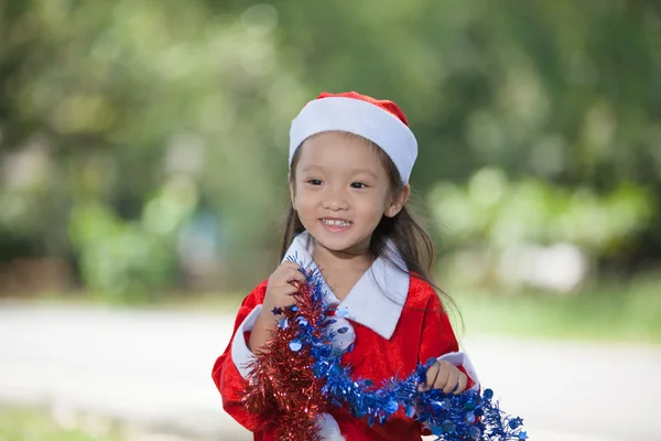 Kleines Mädchen genießt es, sich als Weihnachtsmann anzuziehen — Stockfoto