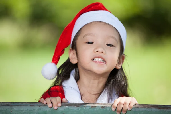 Kleines Mädchen genießt es, sich als Weihnachtsmann anzuziehen — Stockfoto