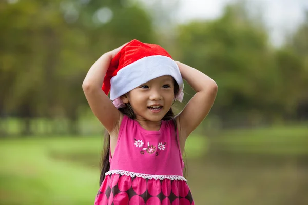 Liten asiatisk tjej med santa hatt — Stockfoto