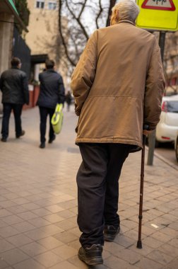 Bastonlu yaşlı bir adam. Sokakta yürürken