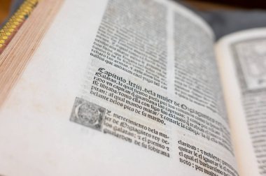 Odağını kaybedip merkeze yönelttiği açık eski bir kitap.