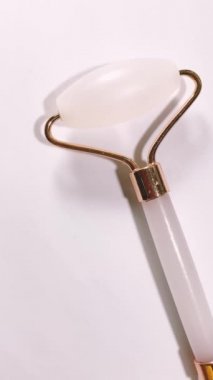 Beyaz arka planda izole edilmiş yüz yakın çekim için beyaz masaj kuvarsı. Kadınlar için güzellik ve bakım konsepti.