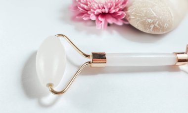 Beyaz arka planda izole edilmiş yüz yakın çekim için beyaz masaj kuvarsı. Kadınlar için güzellik ve bakım konsepti