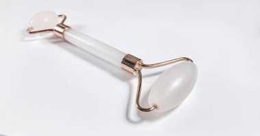 Beyaz arka planda izole edilmiş yüz yakın çekim için beyaz masaj kuvarsı. Kadınlar için güzellik ve bakım konsepti