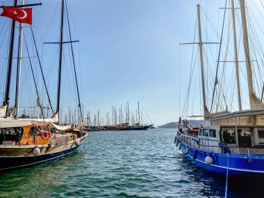 Türkiye 'de dağlara ve denize bakan rıhtımda demirlemiş bir tatil köyü manzarası.