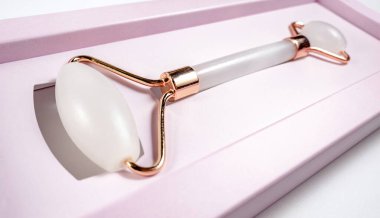 Beyaz arka planda izole edilmiş yüz yakın çekim için beyaz masaj kuvarsı. Kadınlar için güzellik ve bakım konsepti