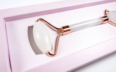 Beyaz arka planda izole edilmiş yüz yakın çekim için beyaz masaj kuvarsı. Kadınlar için güzellik ve bakım konsepti