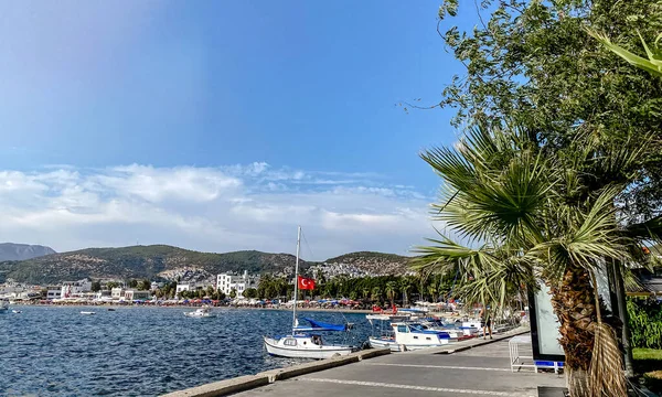 Vista del terraplén de una ciudad turística en Turquía con barcos amarrados en el muelle, palmeras con vistas a las montañas y al mar — Foto de Stock