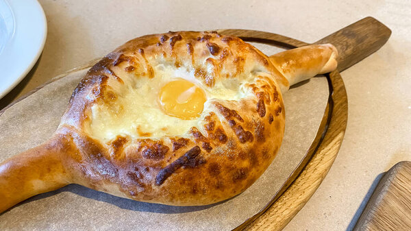 Close-up on a table in a restaurant cooked traditional Georgian dish khachapuri