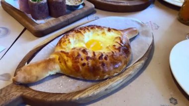 Geleneksel Gürcistan yemeği khachapuri 'nin pişirildiği bir restorandaki masaya yakın plan.