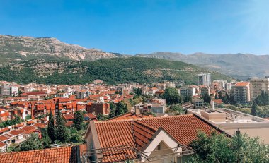 Karadağ 'daki güzel dağların zeminine karşı parlak kırmızı ve turuncu döşemeli evler