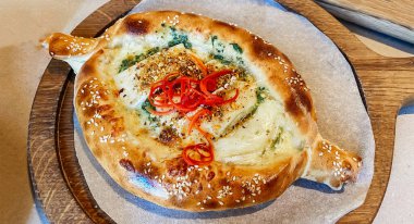 Geleneksel Gürcistan yemeği khachapuri 'nin pişirildiği bir restorandaki masaya yakın plan.