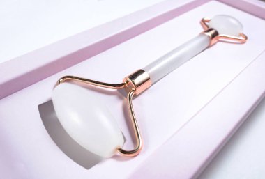 Beyaz arka planda izole edilmiş yüz yakın çekim için beyaz masaj kuvarsı. Kadınlar için güzellik ve bakım konsepti