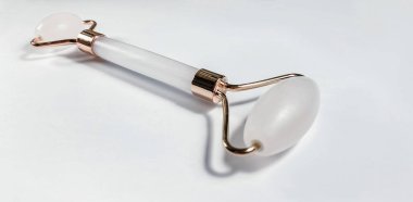 Beyaz arka planda izole edilmiş yüz yakın çekim için beyaz masaj kuvarsı. Kadınlar için güzellik ve bakım konsepti