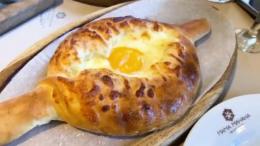 Geleneksel Gürcistan yemeği khachapuri 'nin pişirildiği bir restorandaki masaya yakın plan.