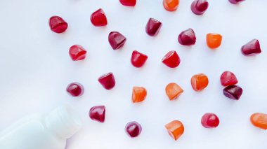 Kırmızı, turuncu ve mor multivitamin sakızları beyaz arka planda izole edilmiş.. 