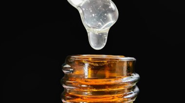 Bir damla yüz serumu olan boru ya da yüz için yağ ve güzel siyah arka planda hyaluronik asit, yakın plan.