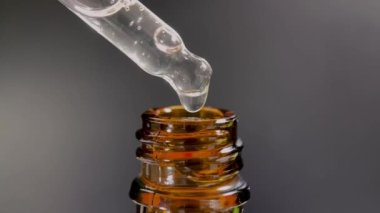 Bir damla yüz serumu olan boru ya da yüz için yağ ve güzel siyah arka planda hyaluronik asit, yakın plan.