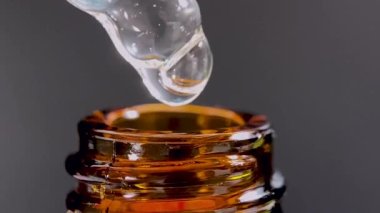 Bir damla yüz serumu olan boru ya da yüz için yağ ve güzel siyah arka planda hyaluronik asit, yakın plan.