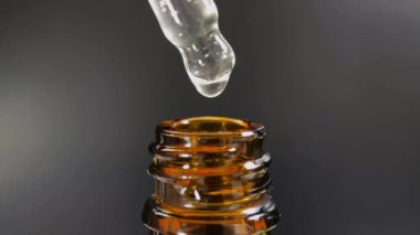 Bir damla yüz serumu olan boru ya da yüz için yağ ve güzel siyah arka planda hyaluronik asit, yakın plan.